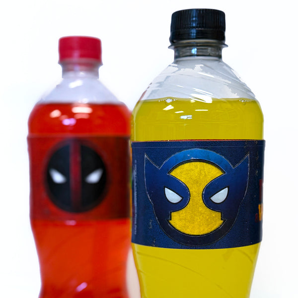 Two bottles with superhero-themed labels, one red and one yellow, on a white background. Close-up of Deadpool and Wolverine drink labels on red and yellow beverages, Marvel superhero party décor for themed birthdays, movie nights, and adult party tables