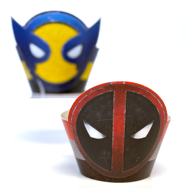Two superhero-themed cupcake wrappers, one resembling Wolverine and the other Deadpool, on a white background.