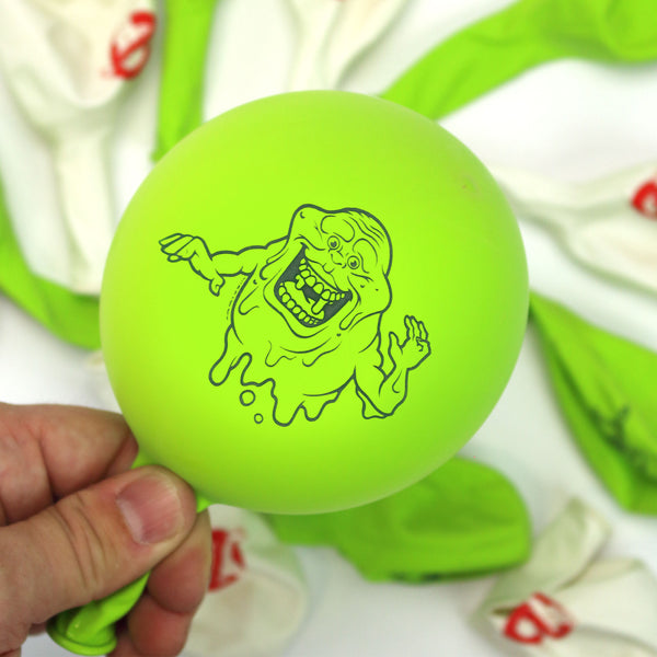  The image features two latex balloons from a Ghostbusters-themed set. The first balloon is white with the iconic red No-Ghost logo prominently displayed in the center. The second balloon is green and features a detailed illustration of Slimer, the mischievous green ghost from the Ghostbusters series, with a wide grin and outstretched arms. Both balloons are inflated and appear to be of high quality, showcasing vibrant and clear graphics.