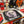 A Halloween-themed party table setup featuring Michael Myers printed paper plates, a black haunted house sign, red drink bottles, red balloons, and spooky decorations.
