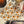 A Halloween-themed paper napkin featuring a repeating pattern of jack-o'-lantern pumpkins and ghostly faces on a white background, styled on a table with a cupcake, a pumpkin, and black spider decorations.