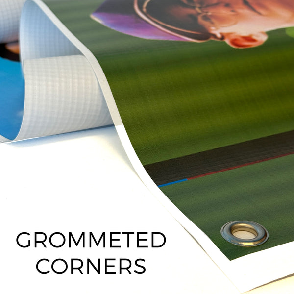 Roll of green vinyl with grommeted corners on a white background.  Vinyl banner with reinforced grommeted corner for easy hanging and secure display.