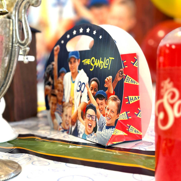 Product packaging for 'The Sandlot' with children's images and a trophy in the foreground.